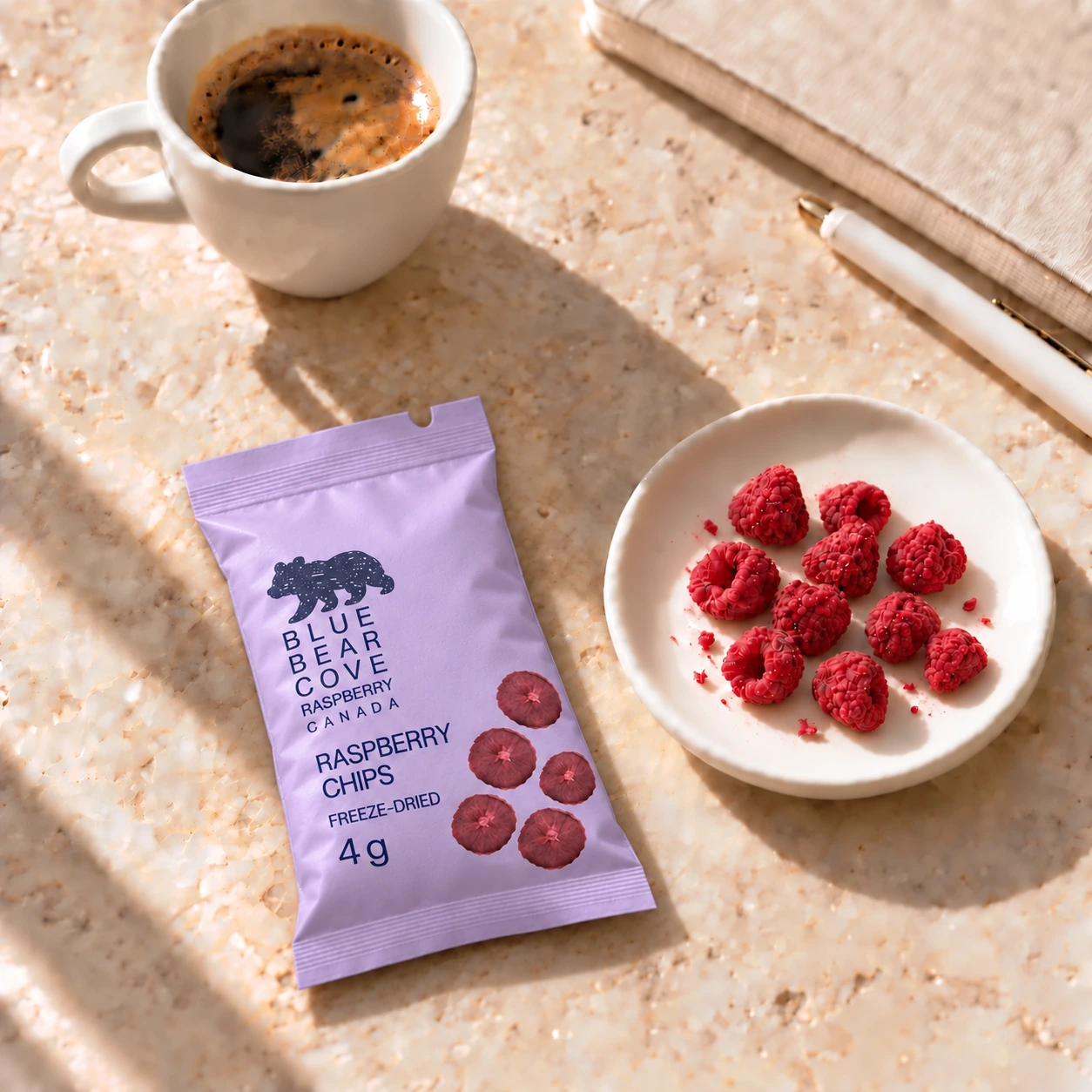 A lavender raspberry chip sachet beside coffee and freeze-dried raspberries.